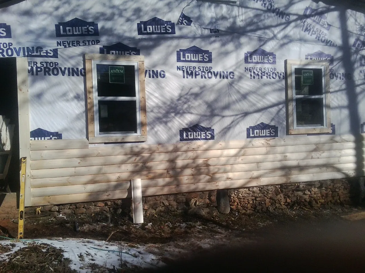 House wrap and new log siding going up on an exterior wall in Bayside